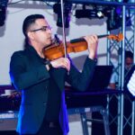 Josué Rugama M. toca el violín en una fiesta con dj