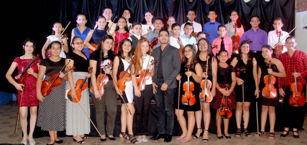 Josué Rugama Martínez con sus 32 estudiantes de violín del Sinem Pococí